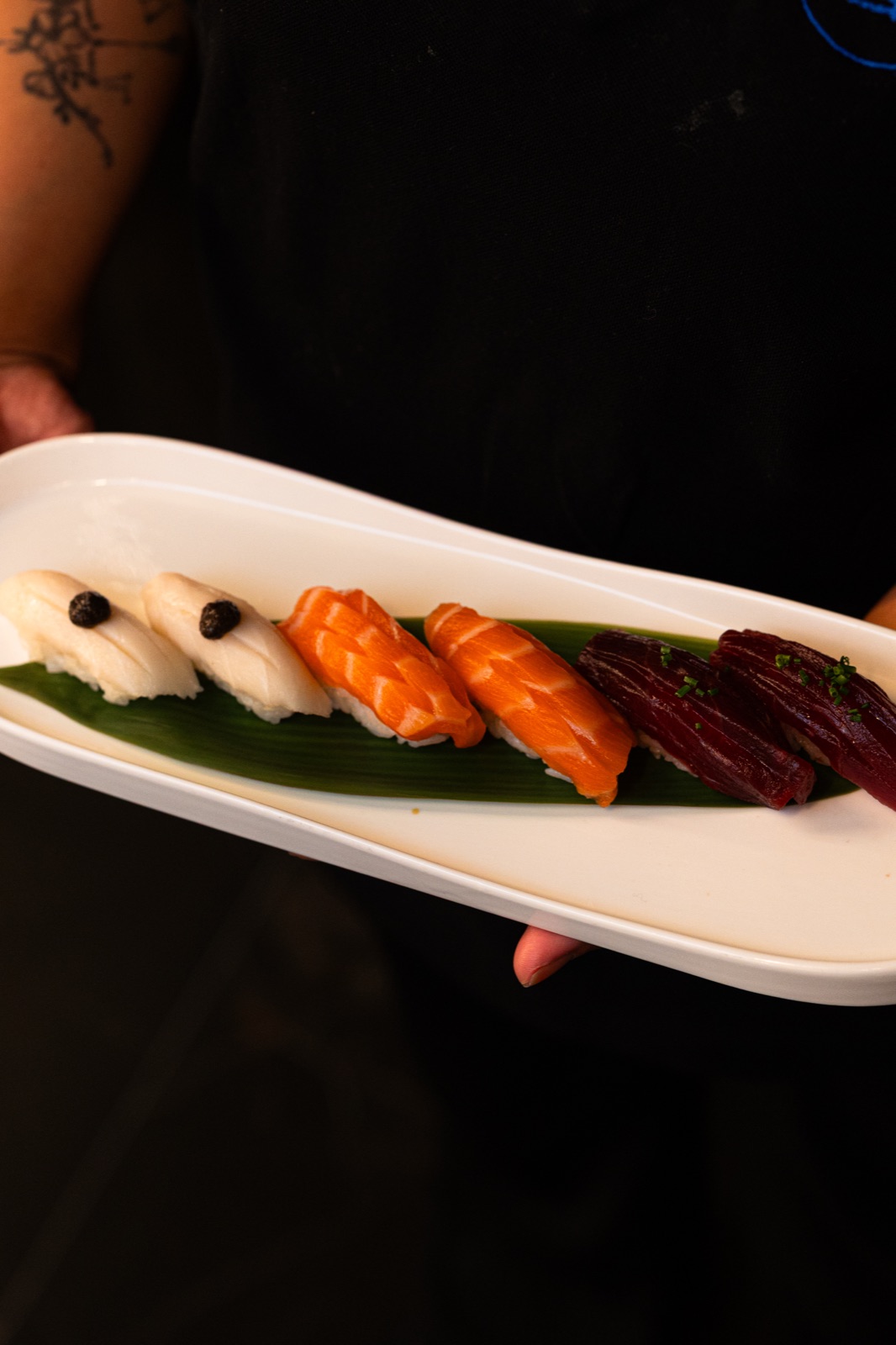Tabla de nigiris de salmón, atún y pez mantequilla recién hechos en Umi Sushi